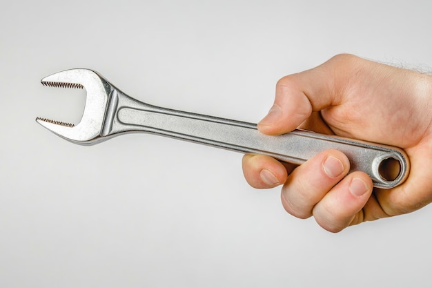 Hand holding an adjustable wrench or adjustable spanner isolated on white background