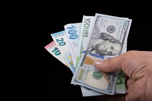 Hand holding American dollar isolated on black background