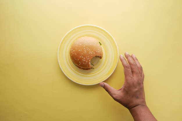 Hand holding beef burger on table close up