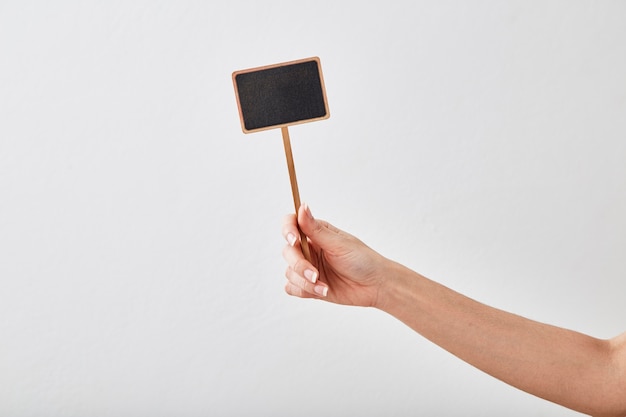 Hand holding a blank blackboard label