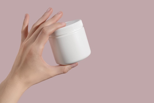 Hand holding blank white plastic supplement container Package mockup blank for capsule