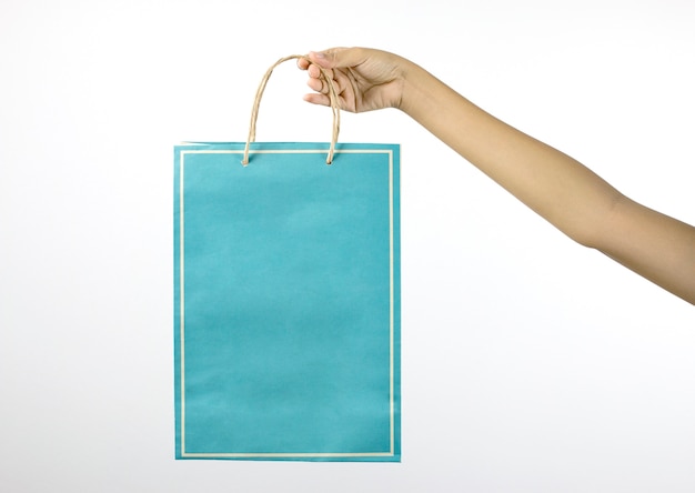 hand holding blue paper bag with white background