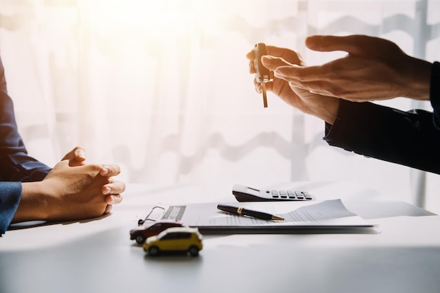 Hand holding car keys and car rental concept A closeup view of the agent giving the customer the car keys after signing the lease rental form and car name