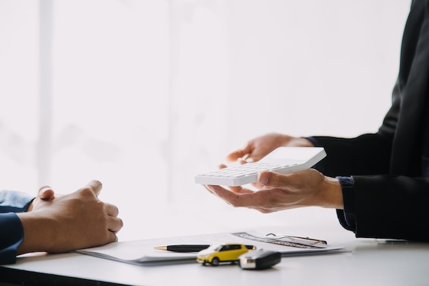 Hand holding car keys and car rental concept A closeup view of the agent giving the customer the car keys after signing the lease rental form and car name