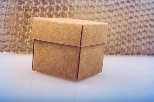 Hand holding cardboard box on a black background