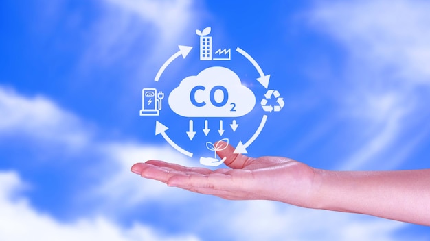 Hand holding CO2 reducing virtual icon for decrease carbon dioxide emission carbon footprint and carbon credit to limit global warming from Bio climate change concept