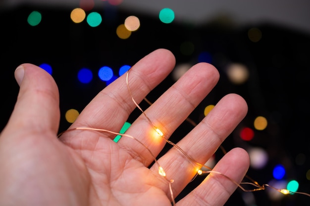 Hand holding Colorful glowing fairy light Holiday festive xmas decoration Christmas lights