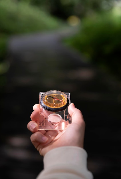 hand holding a compass in nature