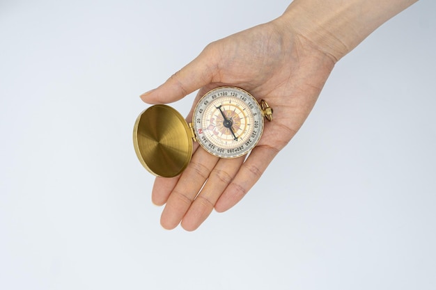 A hand holding a compass with the word compass on it