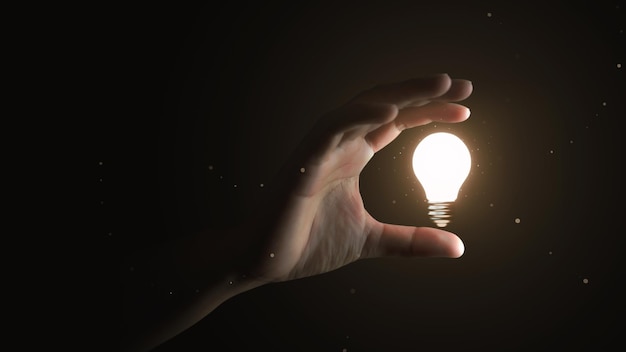 Hand holding creative idea electric light bulb or glowing inspiration lightbulb invention power and success business thinking lamp symbol isolated on black background with innovation achievement goal.