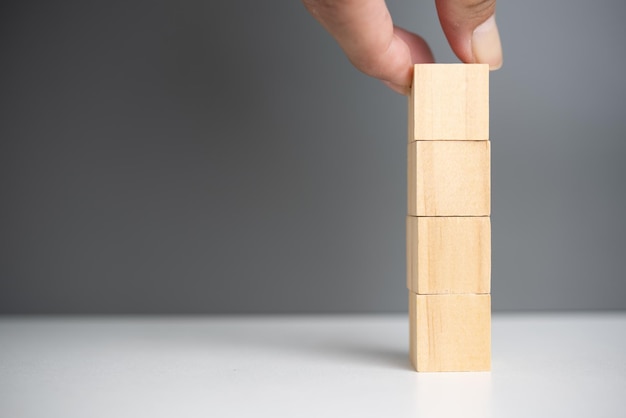 Hand holding cube wood block blank on background copy space