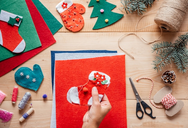 A hand holding DIY Christmas felt stocking, Christmas and New Year children's crafts