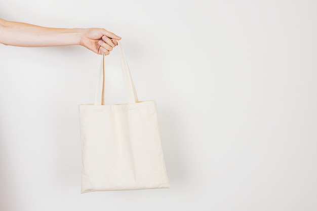 Hand holding empty, clean, eco-frinedly tote bag for zero waste lifestyles concept. 