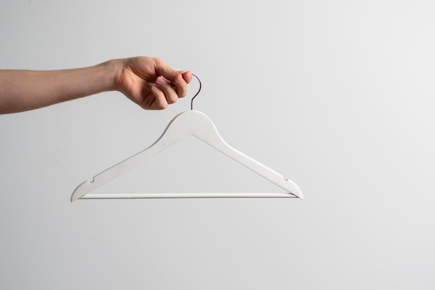 A hand holding an empty cloth hanger