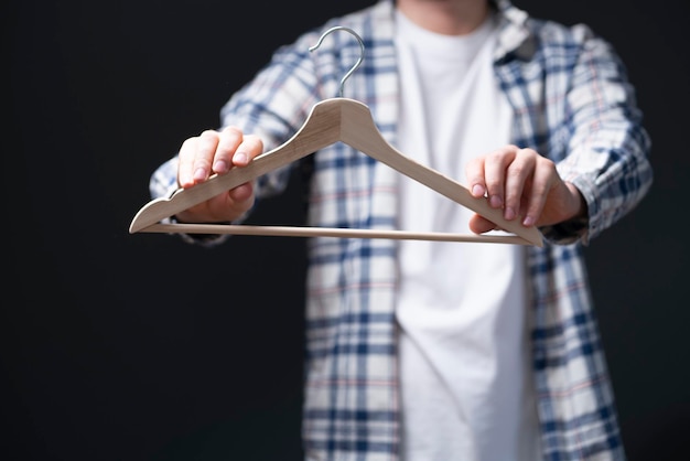 A hand holding an empty cloth hanger