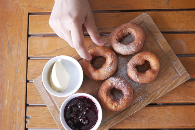 Hand holding fresh donuts top view