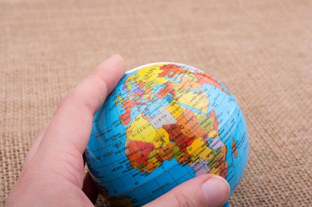 Hand holding a globe on canvas