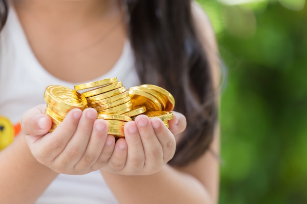 Hand holding golden coins concept on green background