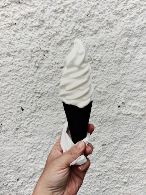 Photo hand holding ice cream cone