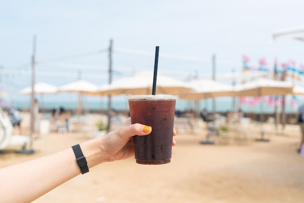 Hand holding iced americano coffee