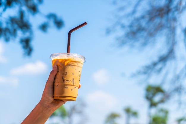 hand holding iced latte coffee cup