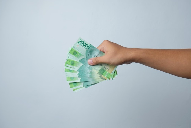 Hand holding indonesian money isolated in white