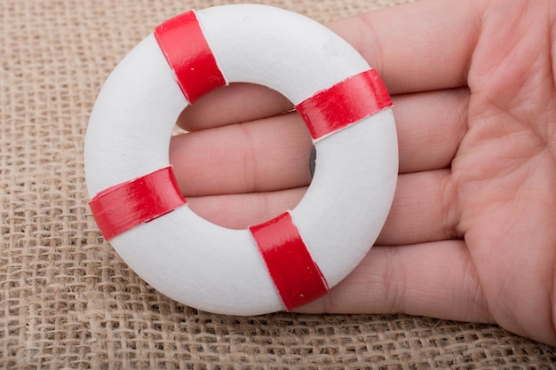 Hand holding a Lifesaver on fabric