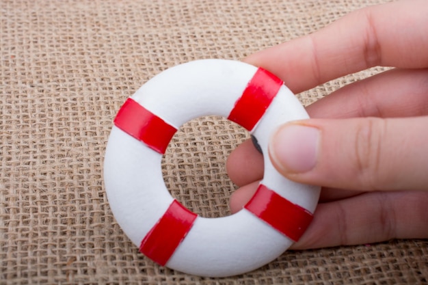 Hand holding a Lifesaver on fabric