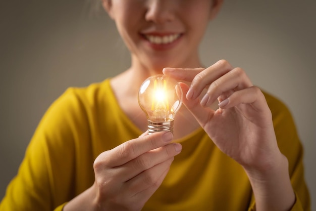 Hand holding a light bulb.Communicating the emergence of creative business ideas or learning