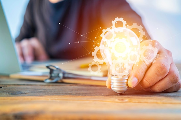 Hand holding a light bulb on the desk idea concept with innovation