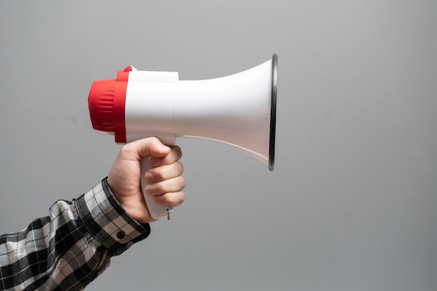 A Hand holding a loud speaker or megaphone against the monochrome background