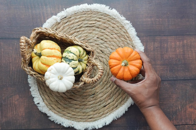 hand holding mini pumpkins wooden background