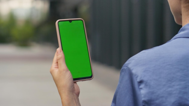 Hand holding mockup smartphone on street closeup businesswoman walking city