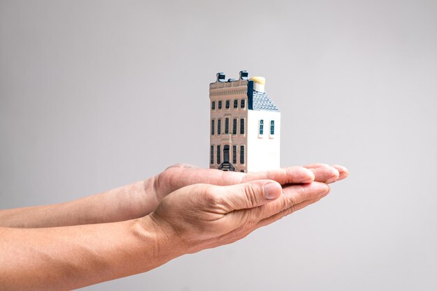 Hand holding a model mansion house Real estate or property concept