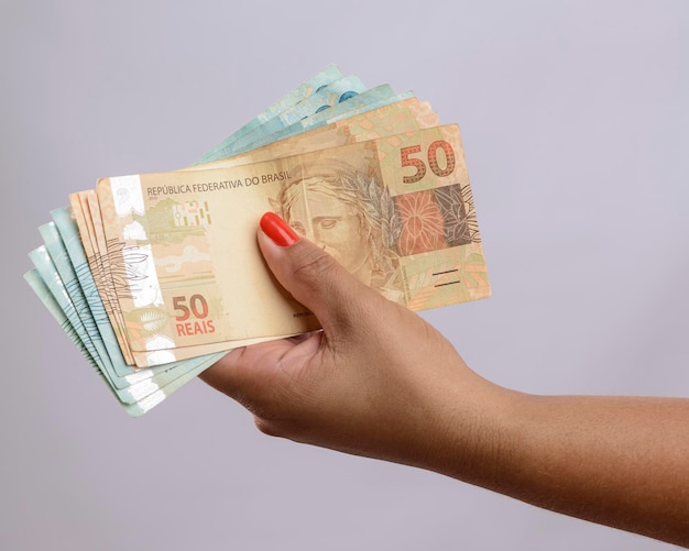 Hand holding money six hundred reais Brazilian currency on white background