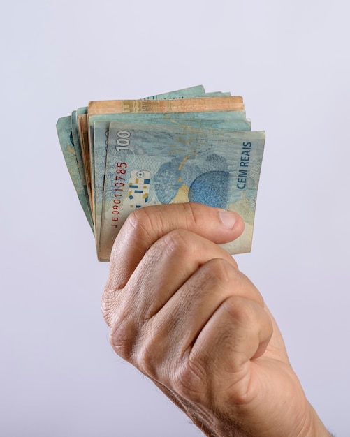 Hand holding money six hundred reais Brazilian currency on white background