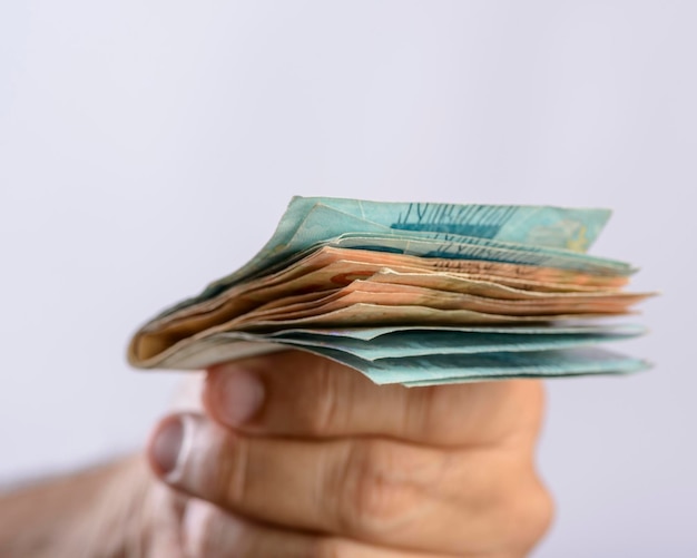 Hand holding money six hundred reais Brazilian currency on white background