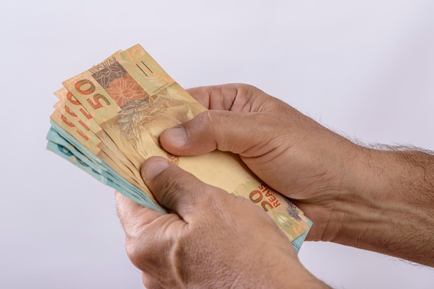 Hand holding money six hundred reais Brazilian currency on white background