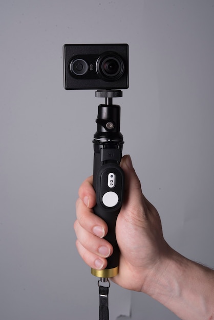 Hand holding a monopod with action camera