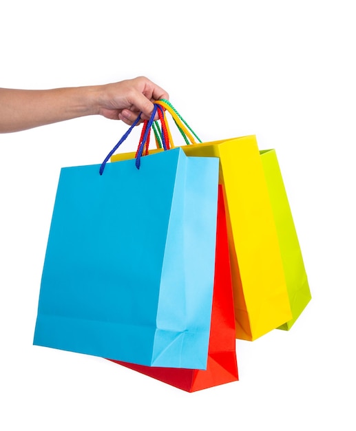 Hand holding multicolored paper bags isolated on white