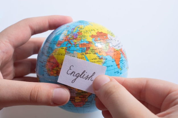 Hand holding notepaper with English wording on globe