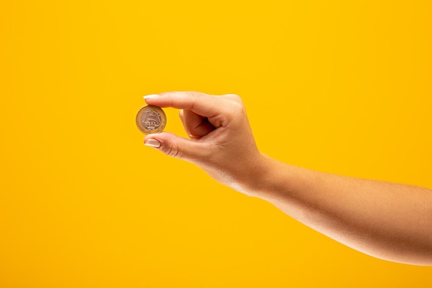 Hand holding one Real coin of Brazil Finance concept.