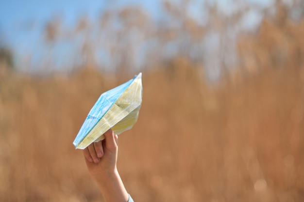 Hand holding the paper flag painted in colors of Ukrainian yellowblue flag Support Ukraine in war