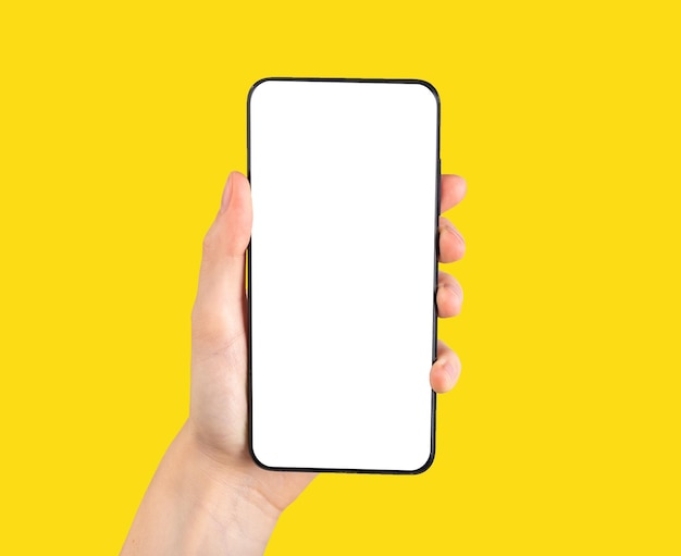 Hand holding phone mockup in vertical position on yellow background Smartphone template with blank screen for mobile application social networking site ad