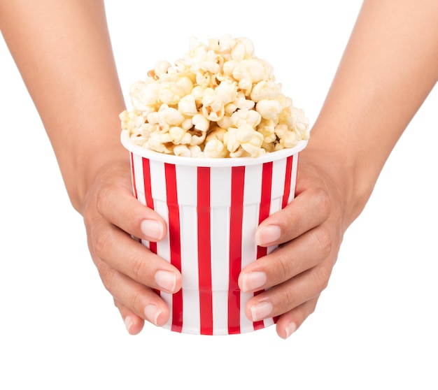 hand holding Popcorn in striped bucket isolated on white background