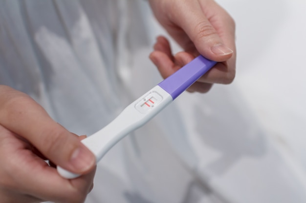 Hand holding the pregnancy test is showing a positive result.