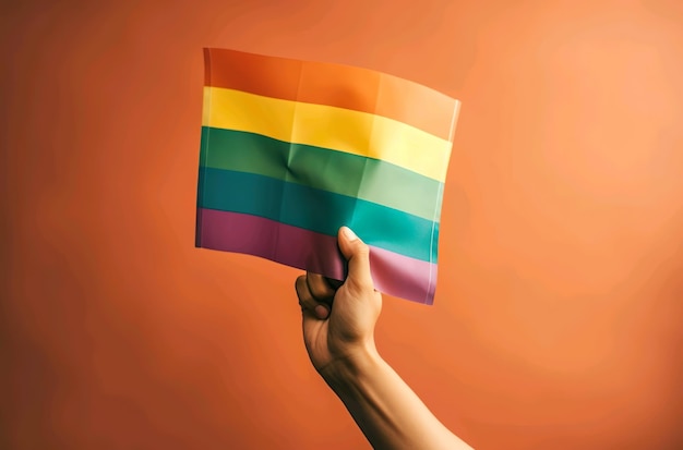 A hand holding a rainbow flag that says'pride'on it