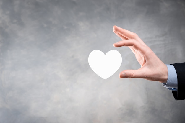 Hand holding red heart with white cross symbol. World map background. Health care, Health insurance, Charity, and Medicine concept. Copy space.