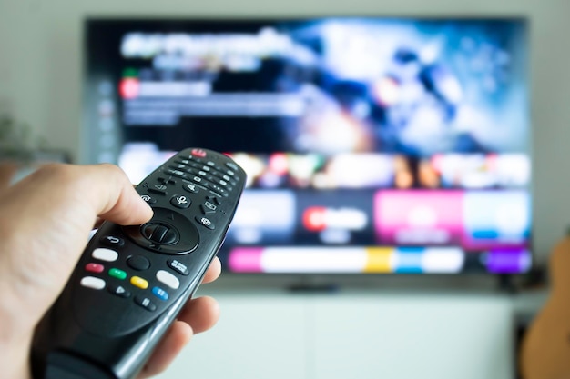 Hand holding a remote to browse TV shows or series