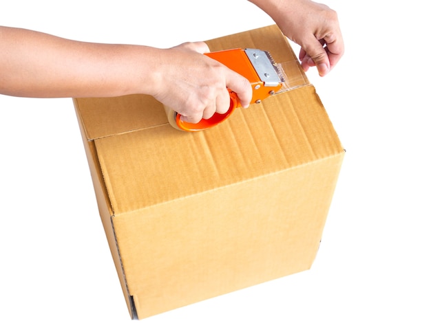 Hand holding roll of clear plastic packing tape and brown box isolated on white background.